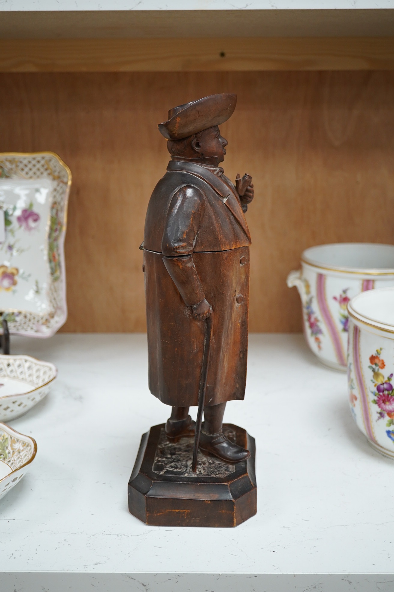 A 19th century Black Forest figure of a gentleman smoking a pipe, hinged at the waist to hold tobacco?, 36.5cm high. Condition - poor to fair, the shaft of his pipe is missing and the rear section of his hat